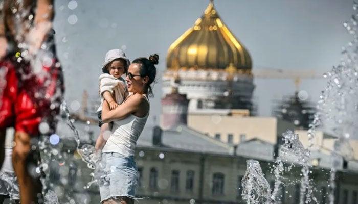 People cool off in front of Moscows Christ the Saviour Cathedral, as the Russian capital sweltered under record heat. — AFP/File