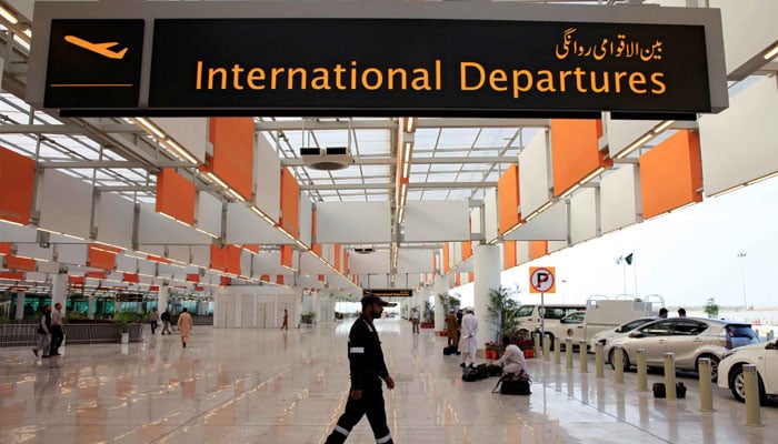 A worker passing below the board of International Departure at Jinnnah International Airport Karachi. —TheNews/File