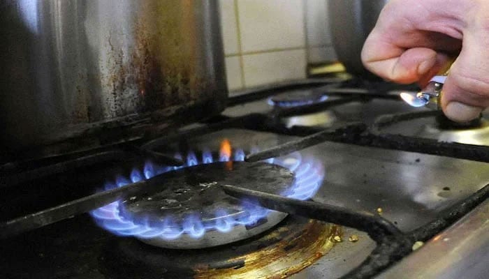 A representational image of a person lighting a stove. — AFP/File